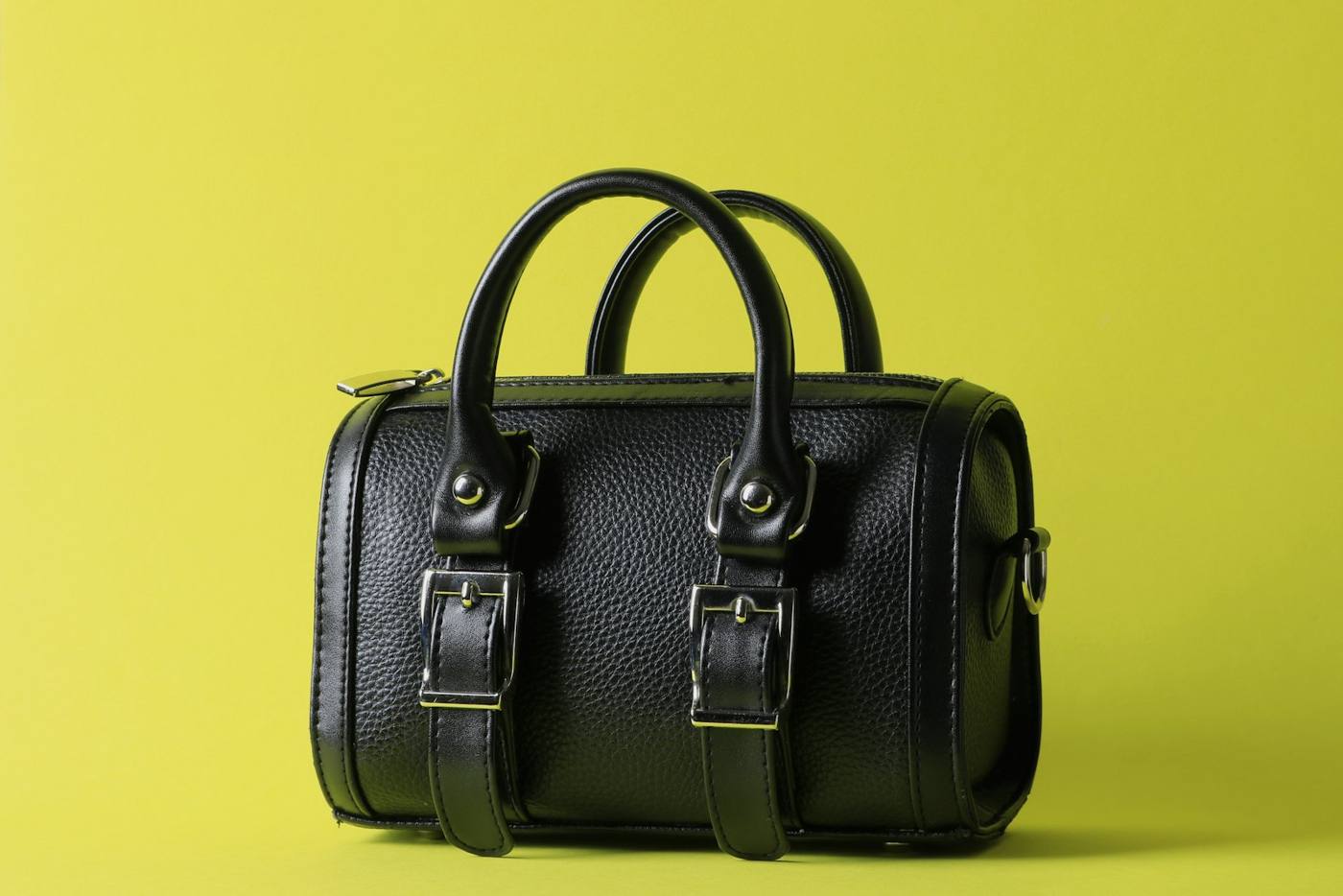 Black leather bag on a yellow background