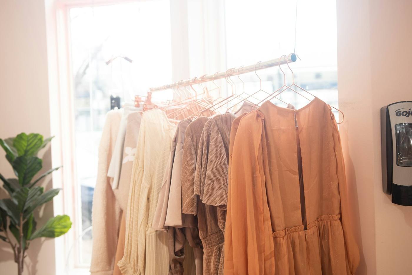 A rack of clothes beside a window